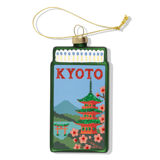 Kyoto matchbook ornament with green cover, gold chain, scenic temple illustration.