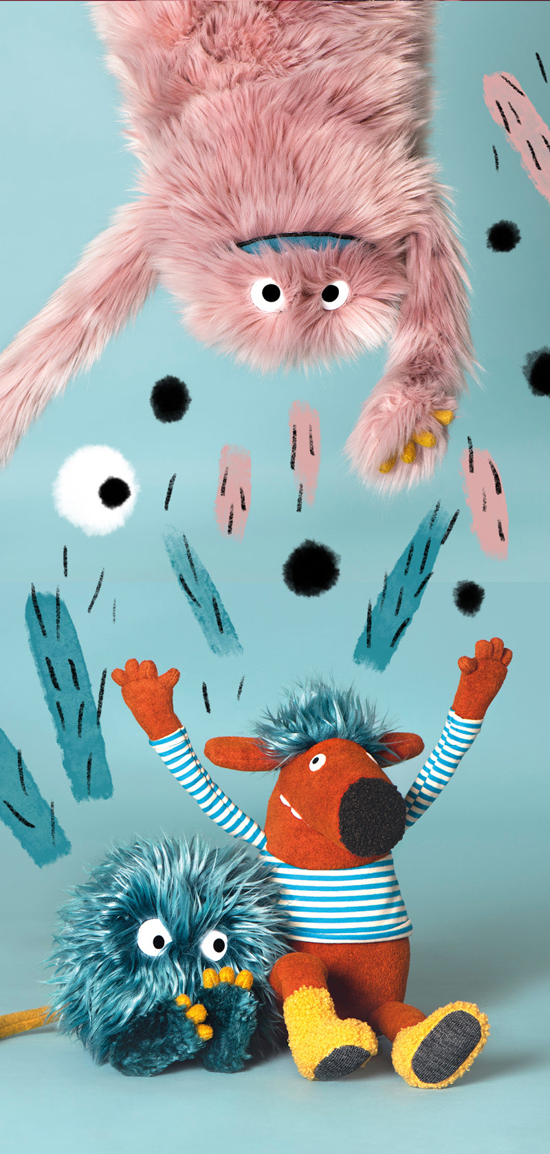 Pink furry stuffed toy monster with wide eyes, teal paws, and long arms.