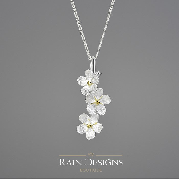 Silver forget-me-not flower necklace with three dangling blossoms and chain link collar.