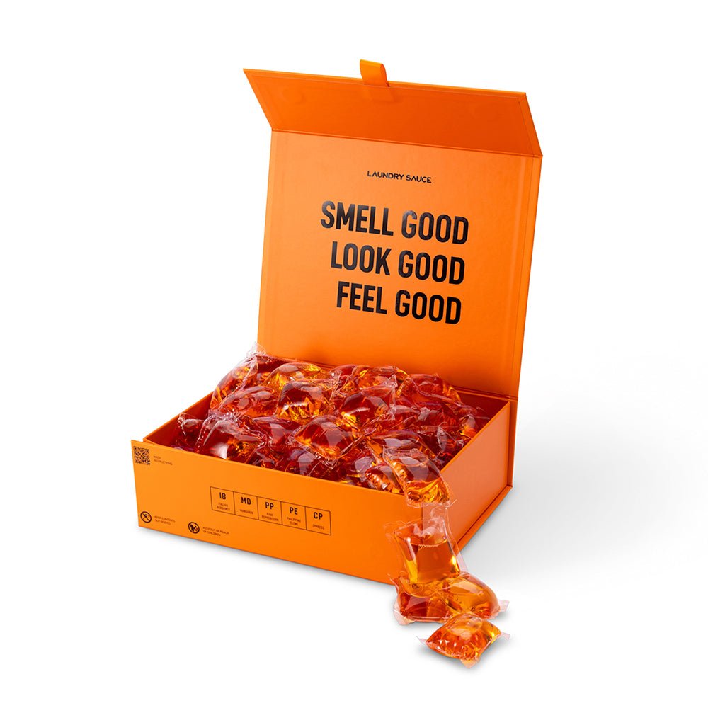 Orange open box of laundry detergent pods with amber-colored wrapped pods
