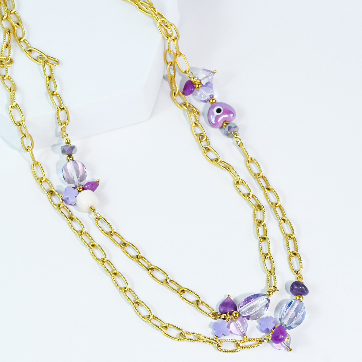 Layered gold necklace with purple bead and flower charms, multi-strand chain