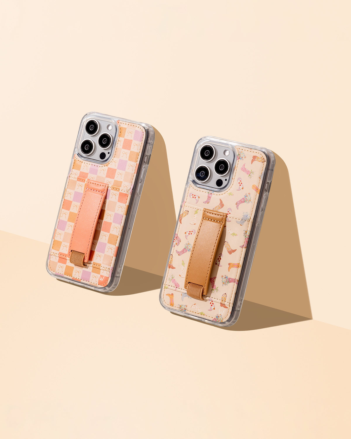 Two peach bow patterned phone cases with tan strap and clear edges