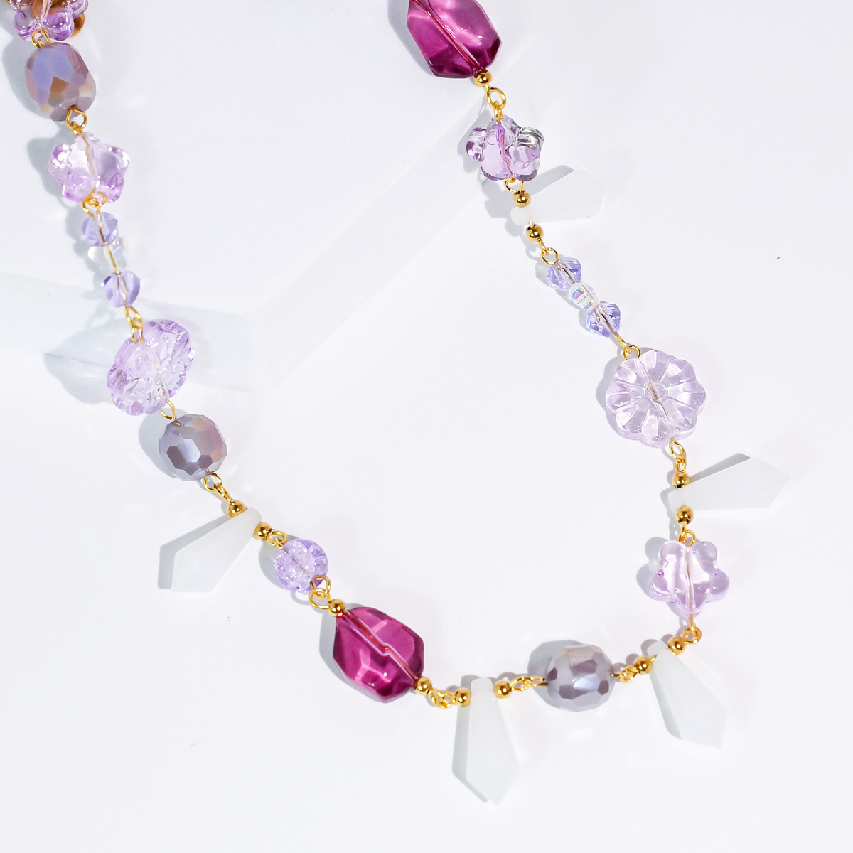 Lavender beaded necklace with purple flower charms and gold-tone links, adjustable chain