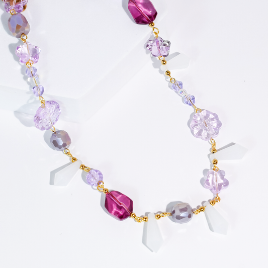 Lavender beaded necklace with purple flower charms and gold-tone links, adjustable chain