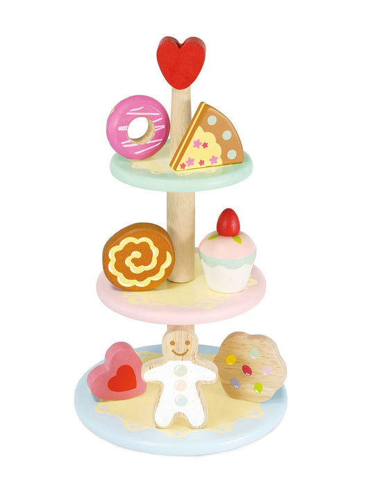 Three-tier cake stand with heart topper and toy desserts on tiers