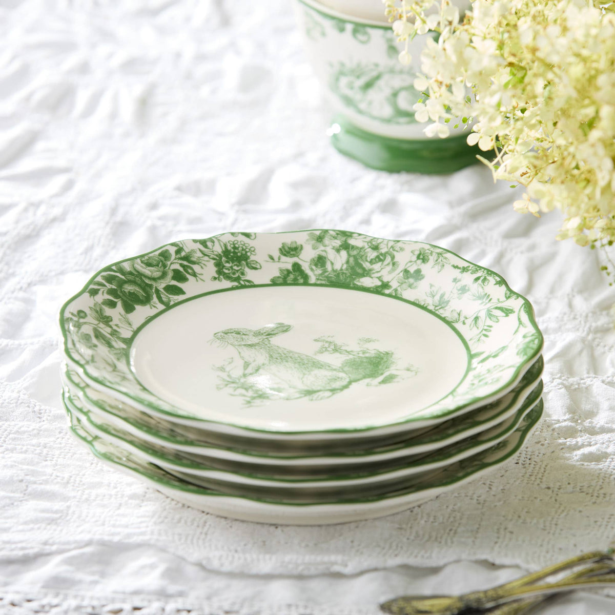 Green-and-white Easter rabbit plate set on white tablecloth, scalloped green rim