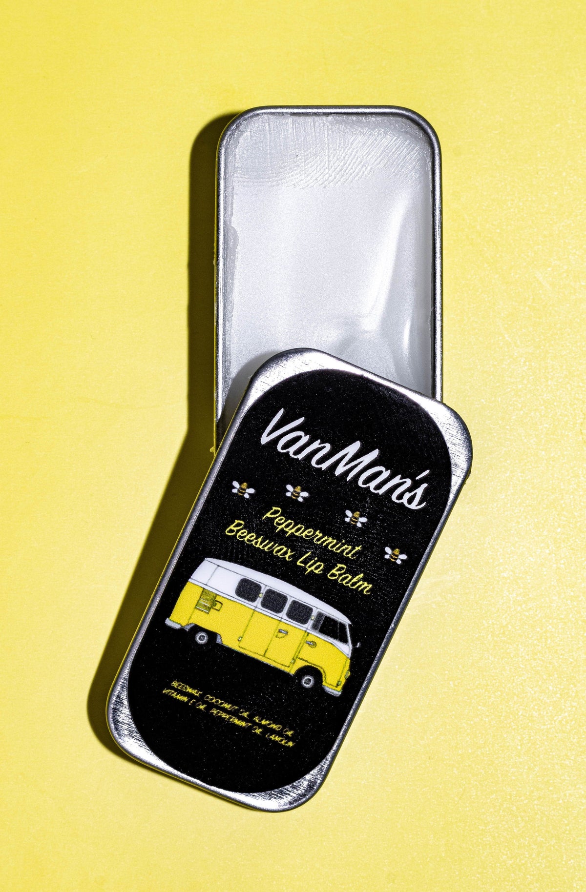 Peppermint beeswax lip balm tin with yellow bus label, close-up