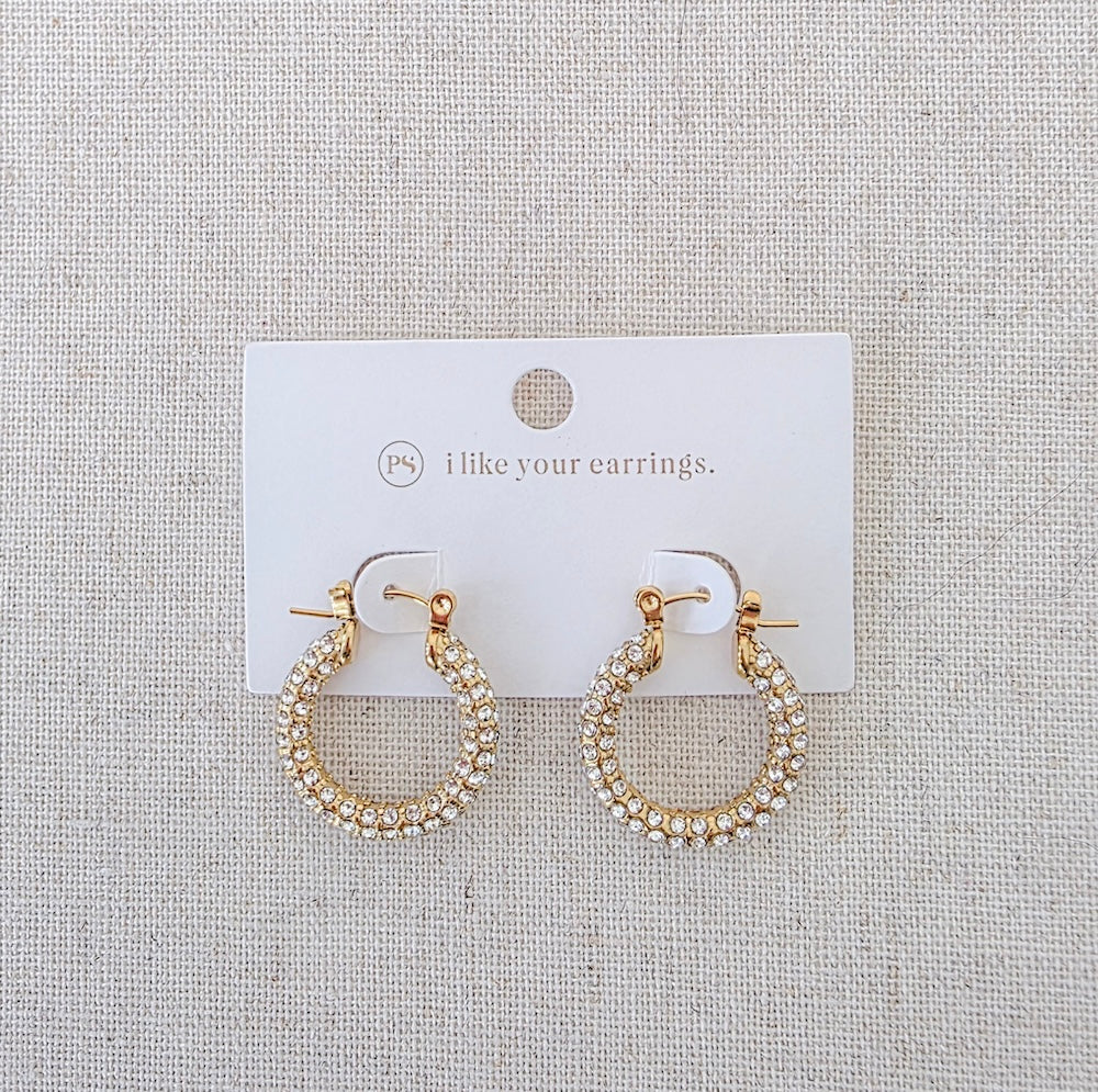 Gold pavé hoop earrings on a display card