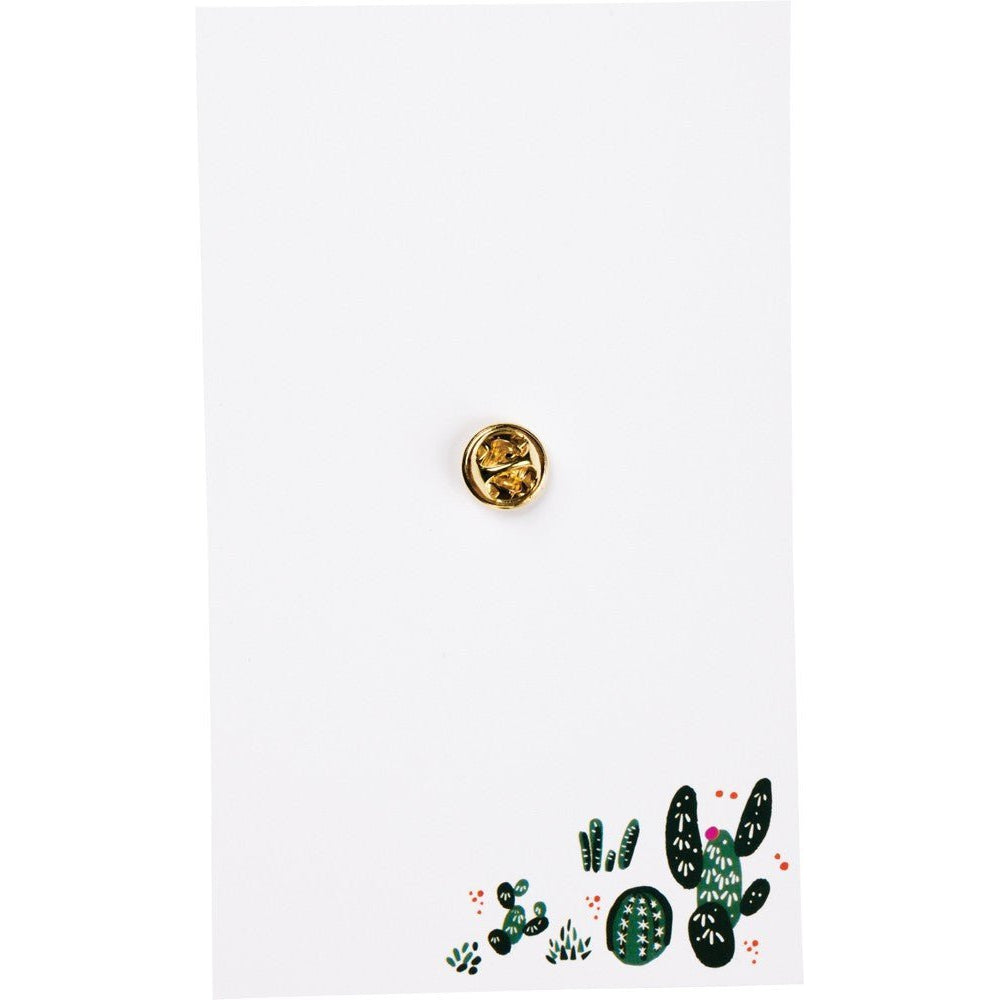 Cactus enamel pin backer card with a small gold-tone pin on white background
