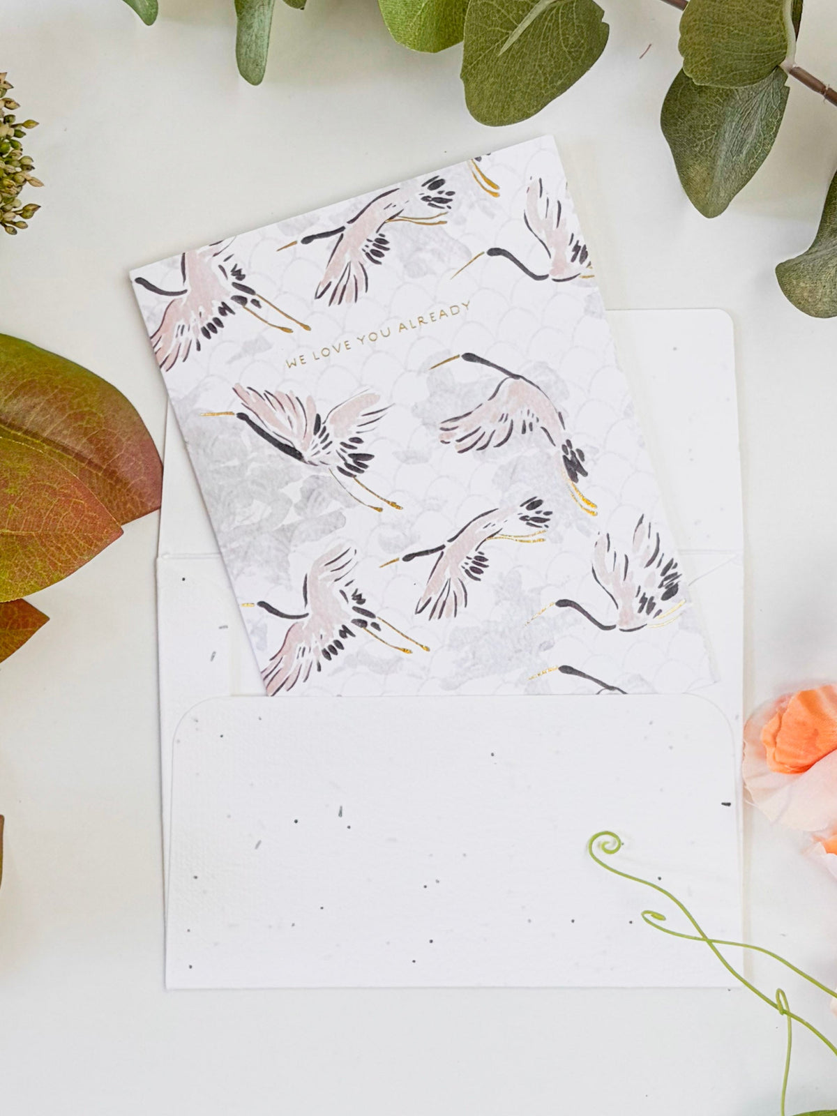 Seeded baby congratulations card, white cover with pink/black/gold feather pattern