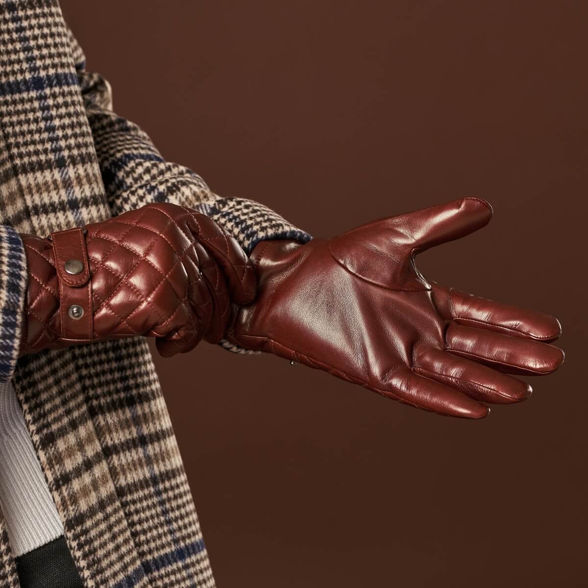 Brown leather gloves with quilted diamond panels and snap wrist strap
