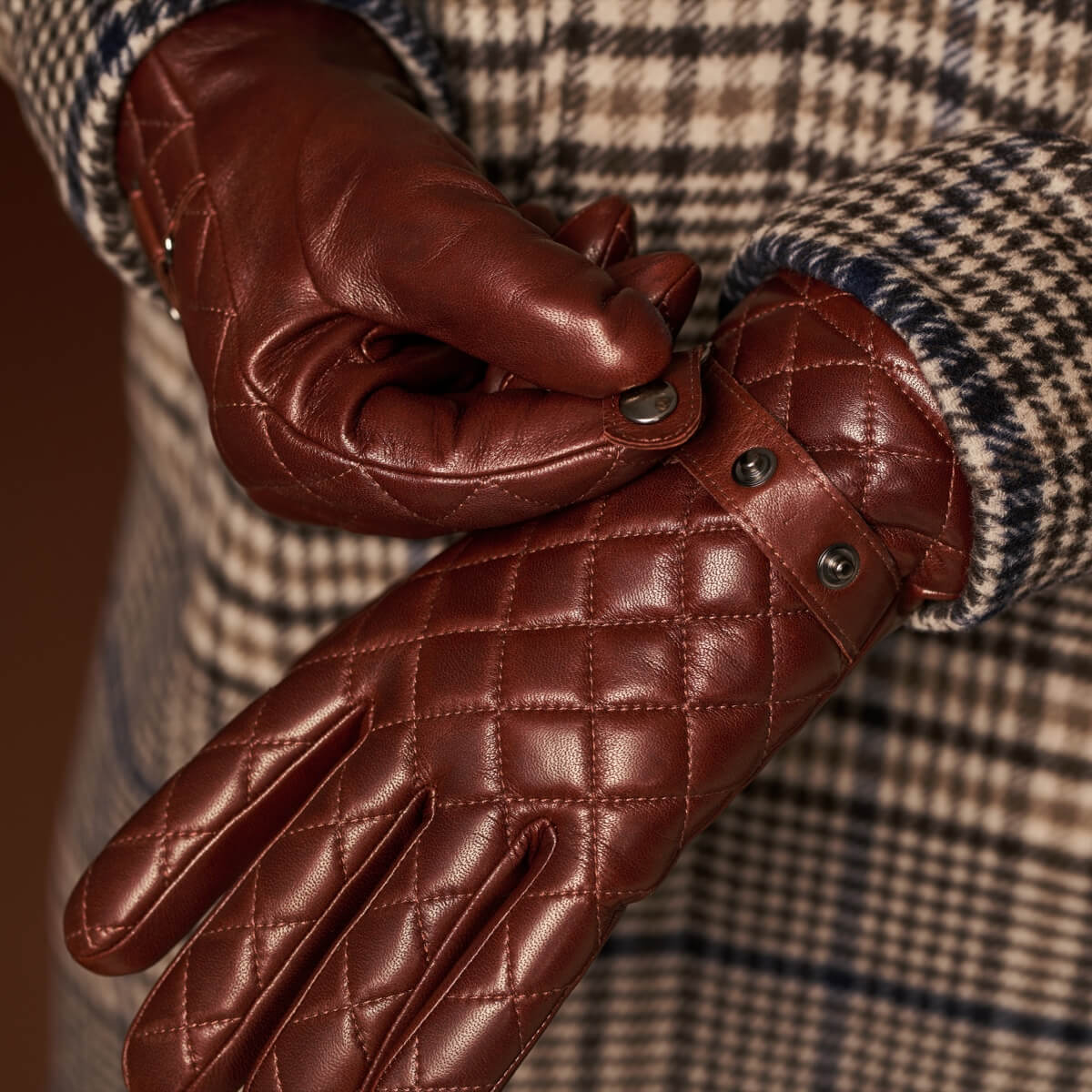 Brown lambskin leather gloves with diamond stitching and metal button details