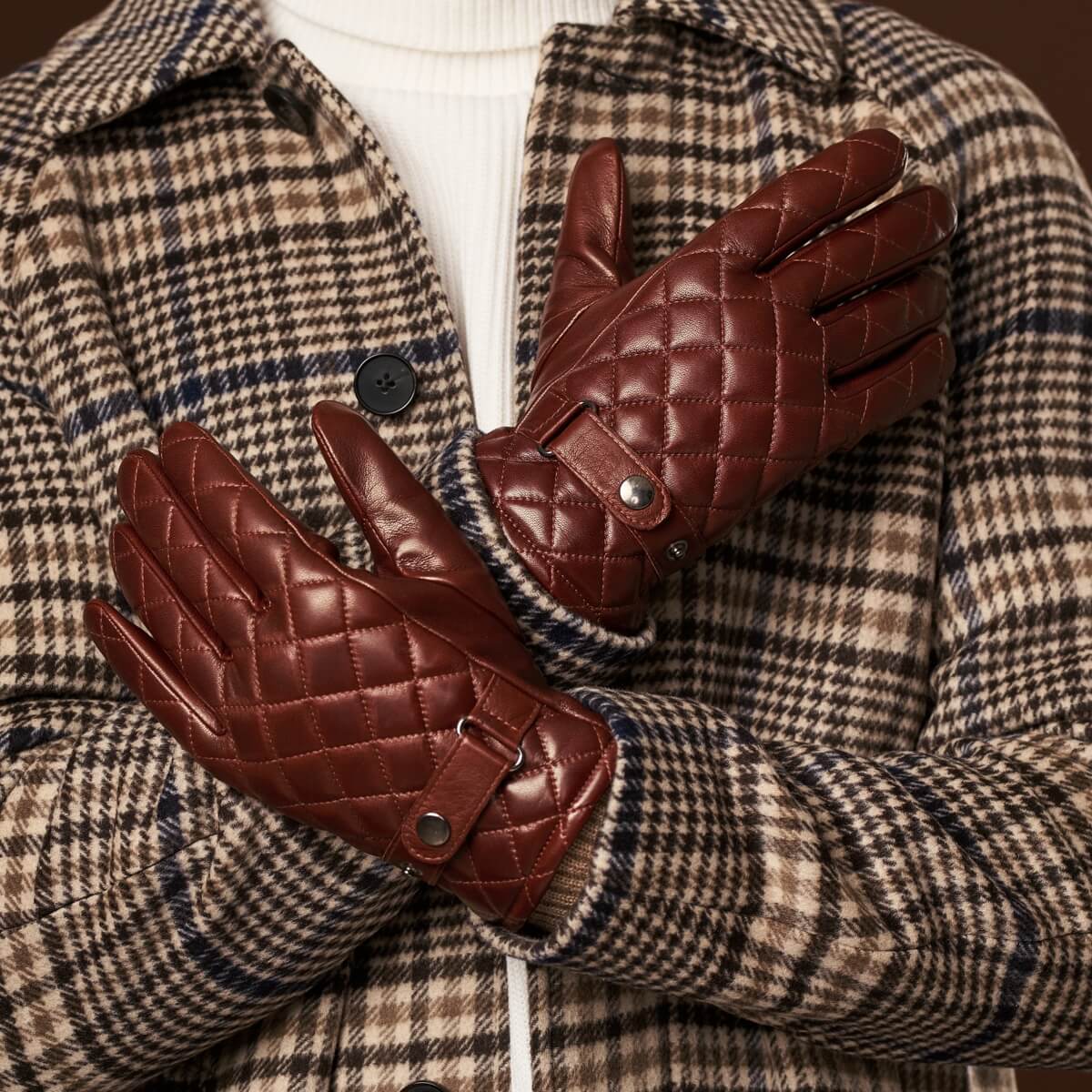 Pair of brown quilted leather gloves with button strap and ribbed knit cuffs