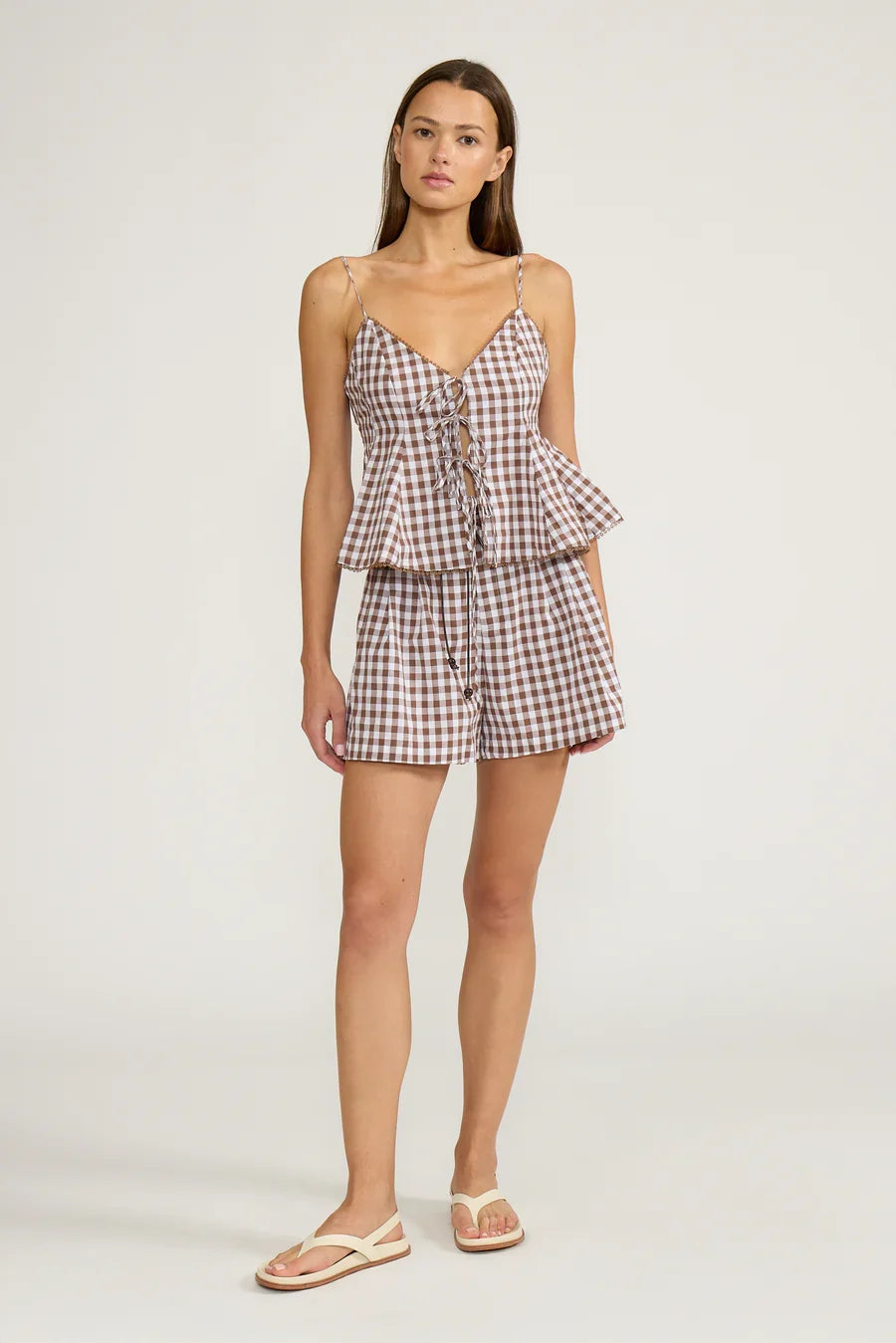 Brown gingham peplum tank top with spaghetti straps, lace-up front
