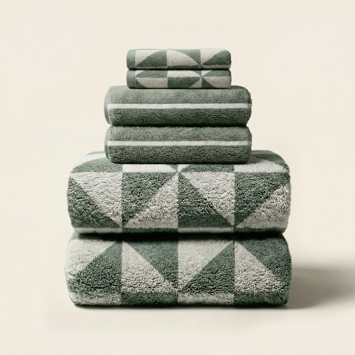 Stacked cotton bath towels, sage-green terry with ecru diamond pattern