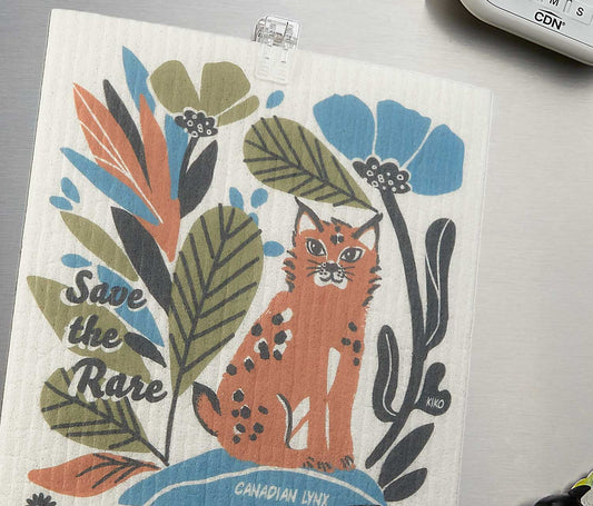 Swedish dishcloth close-up featuring orange lynx and foliage artwork
