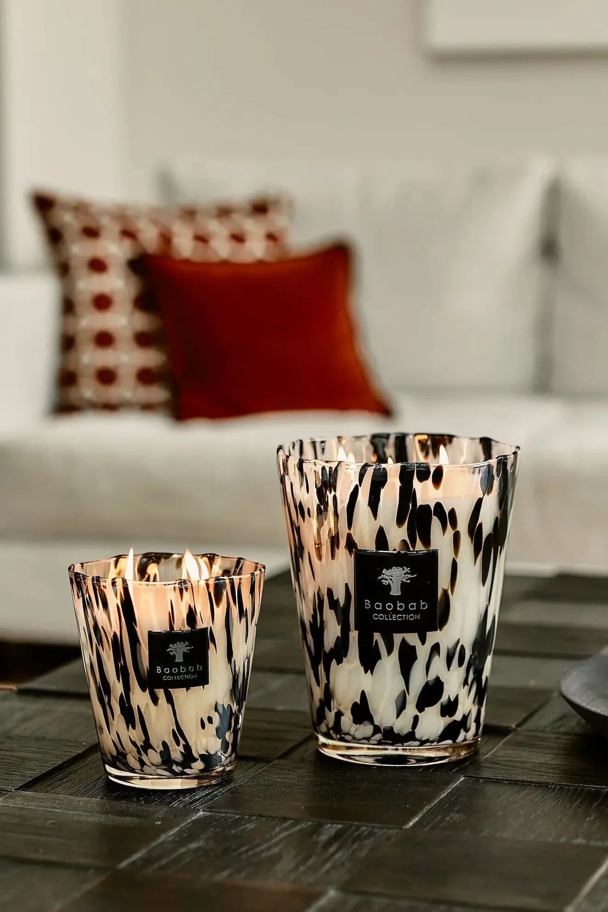 Baobab Black Pearls candle pair in leopard-print glass on wooden surface