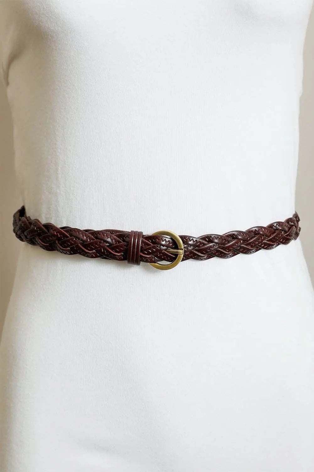 Brown braided leather belt with gold round buckle on a waist model