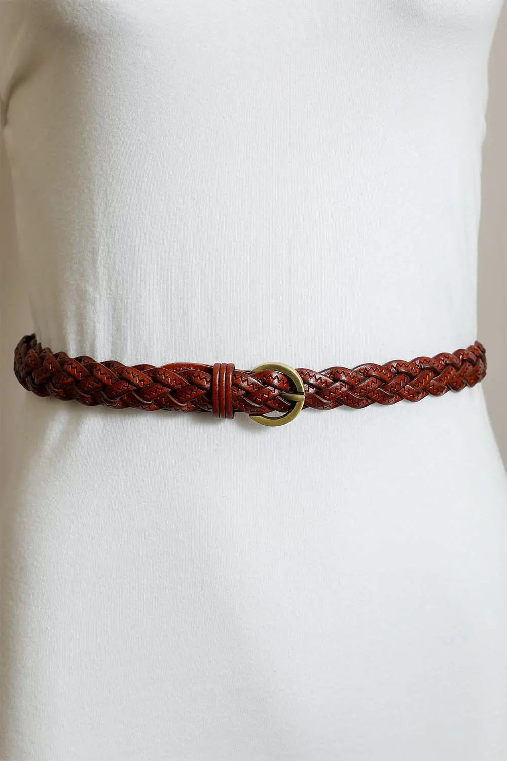 Rust-brown braided leather belt with gold round buckle on a waist model