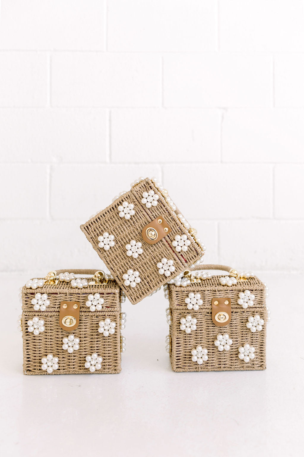 Set of three raffia mini handbags with pearl flower embellishments and gold clasps
