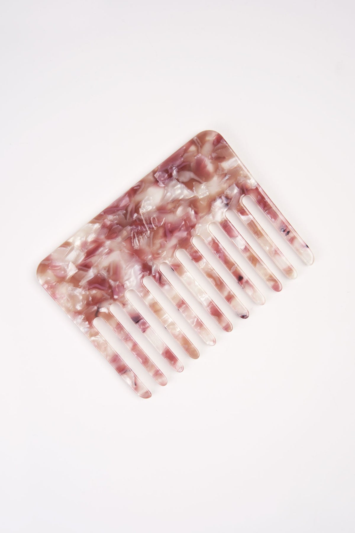 Rose marble-effect hair comb with wide white teeth, angled view