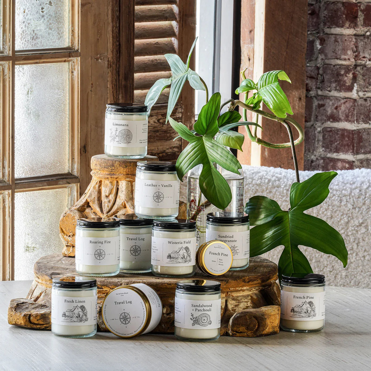 Assorted jar candles in clear glass with black lids and printed labels