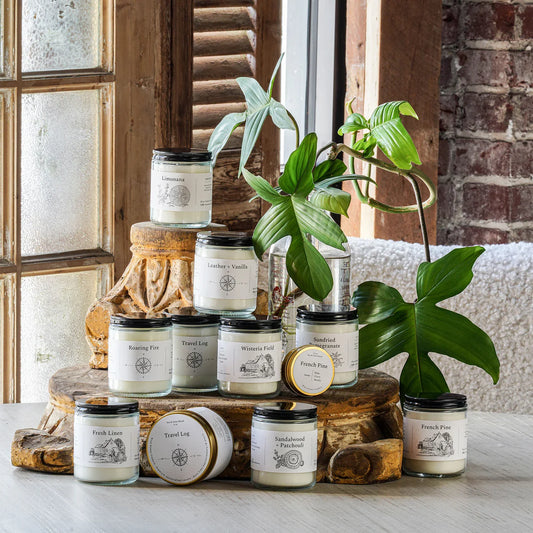 Assorted jar candles in clear glass with black lids and printed labels