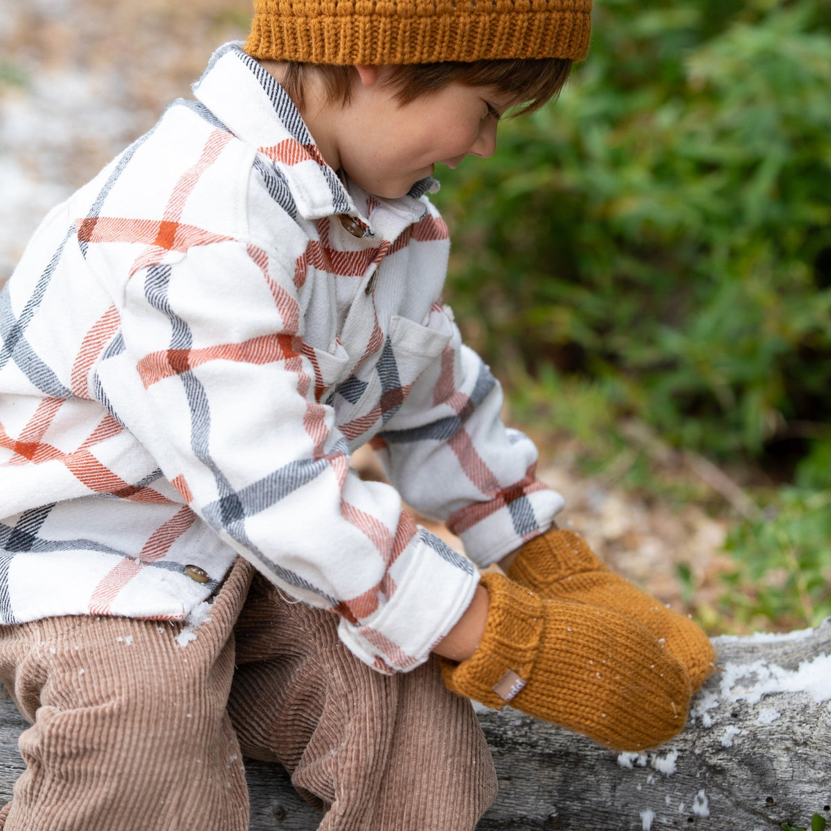 Brown knit mittens with ribbed cuffs worn by a child