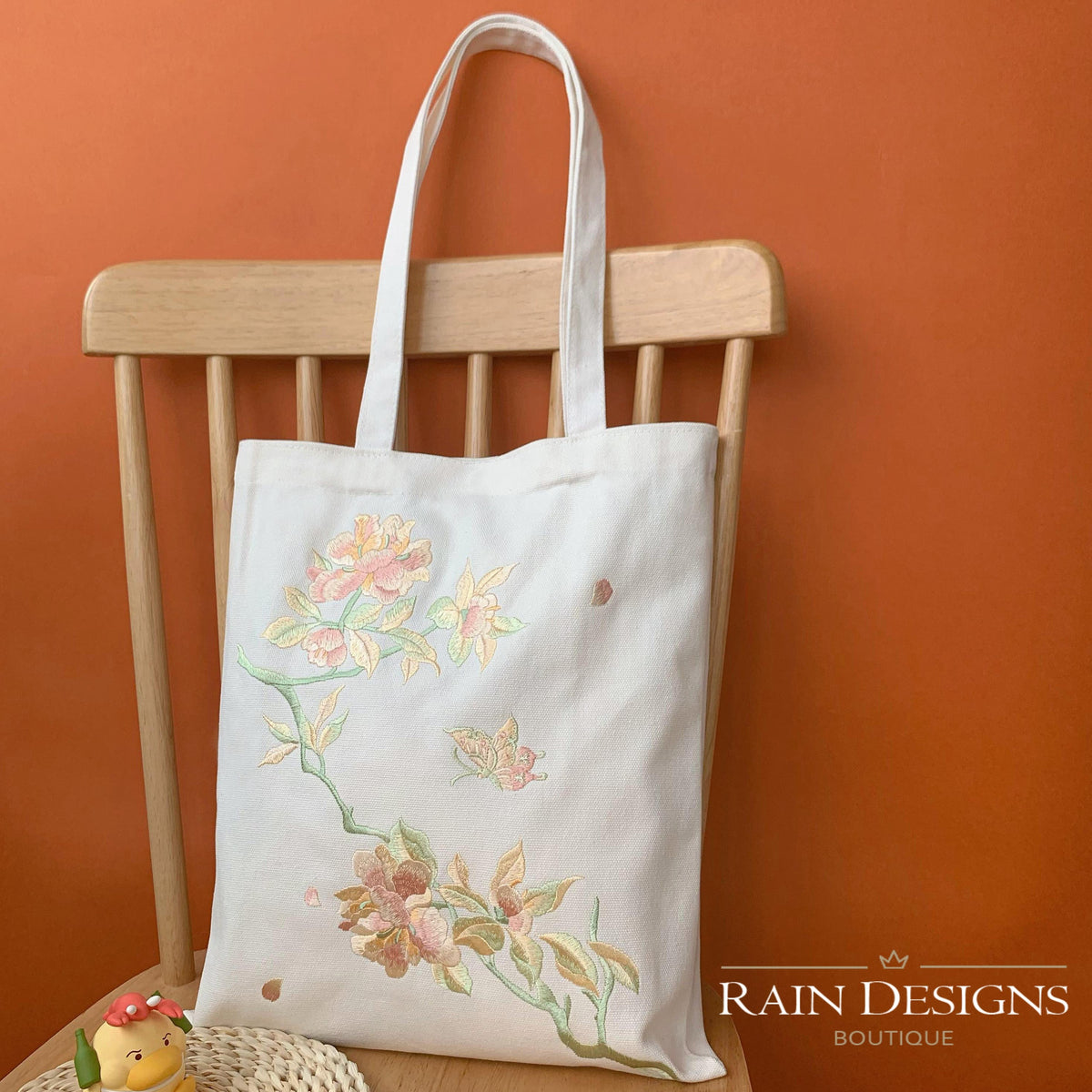 White tote bag with peony and butterfly embroidery on front panel