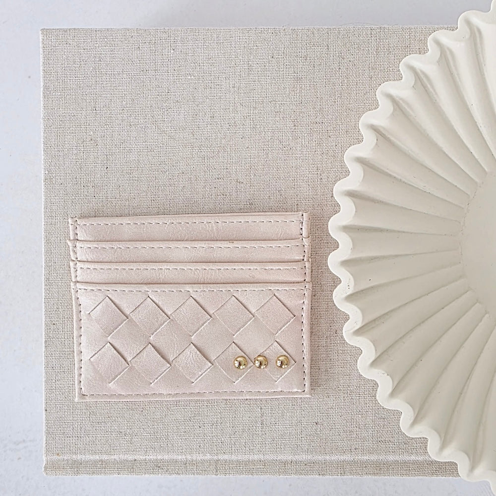Cream woven small card holder wallet with embossed pattern and gold studs.