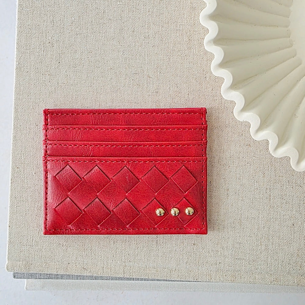 Cherry red woven small card holder wallet with embossed pattern and gold studs.