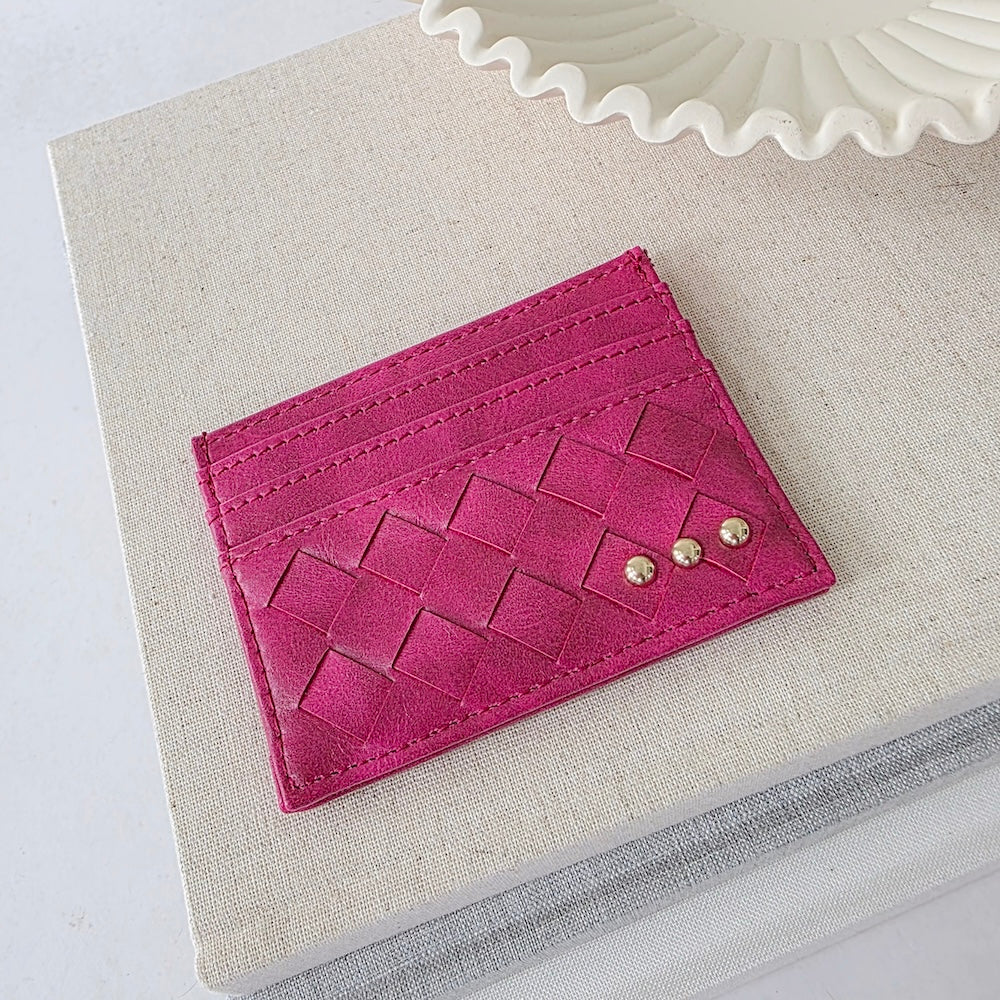 Fuchsia woven small card holder wallet with embossed pattern and gold studs.