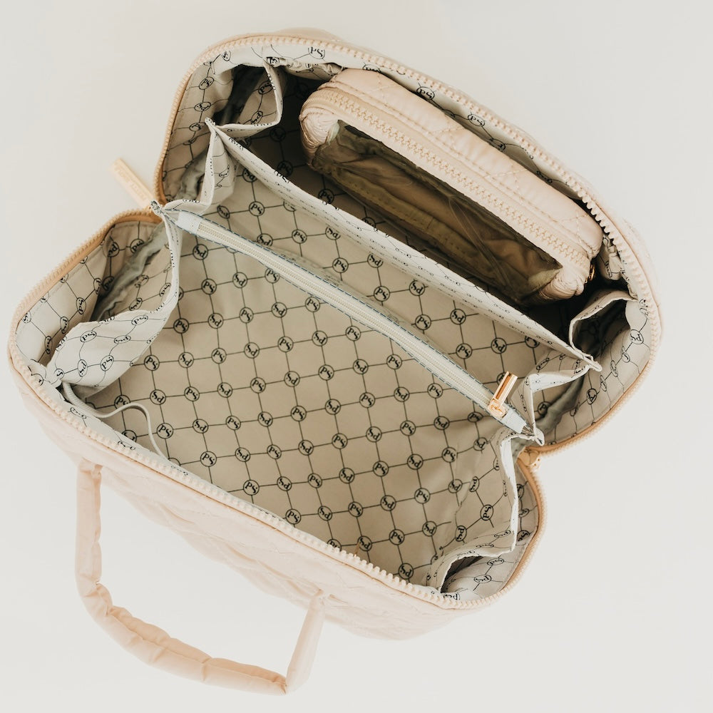 Taupe quilted cosmetics bag open view, showing patterned lining, pockets, and zipper top.