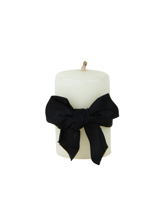 Ivory pillar candle with large black bow ribbon across front, smooth wax cylinder