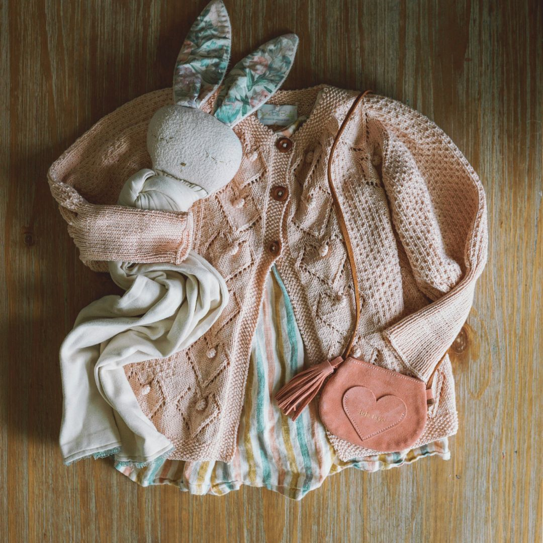 Beige knit cardigan with button front and textured diamond pattern, long sleeves.