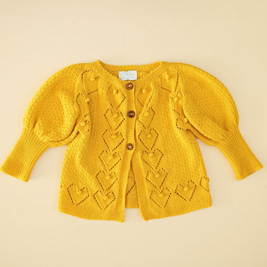 Yellow knit cardigan with button front, diamond pattern, and long sleeves.