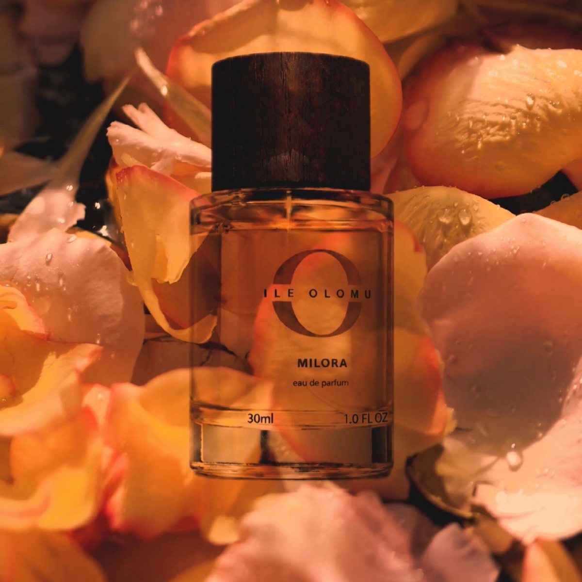 30ml eau de parfum bottle with dark wooden cap, over scattered petals