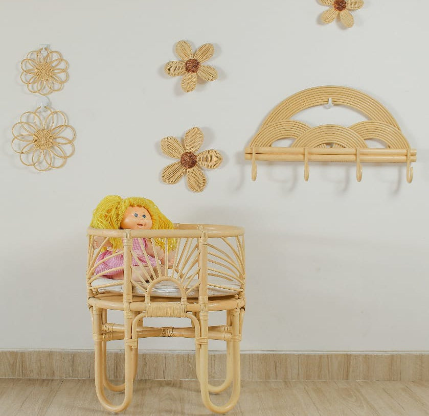 Woven toy bassinet with a doll and curved legs