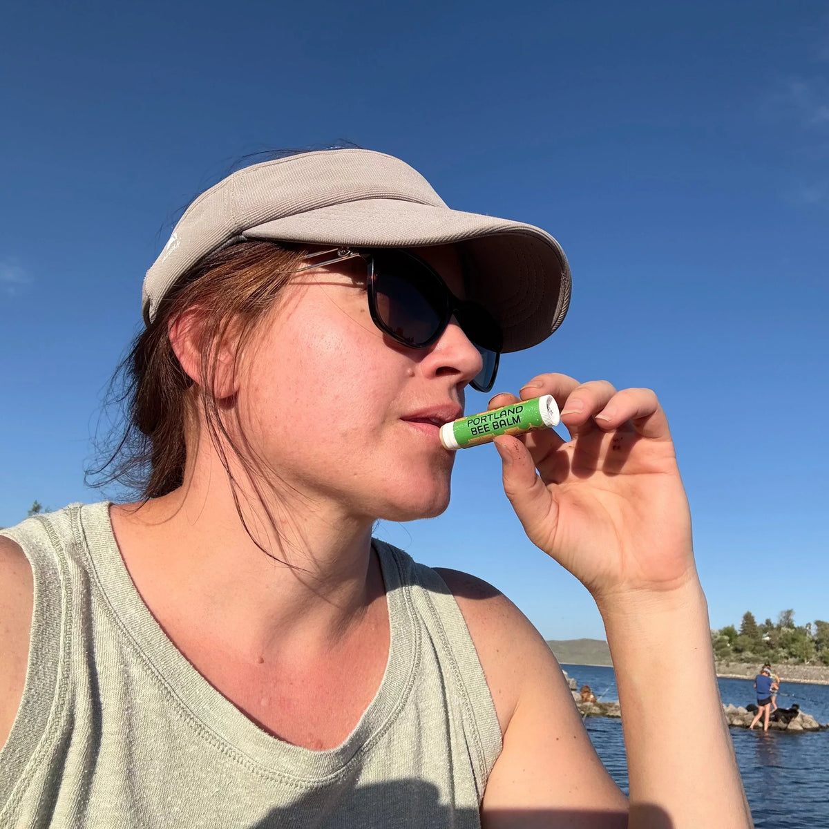 Person applying Oregon mint lip balm from a small stick held near the mouth