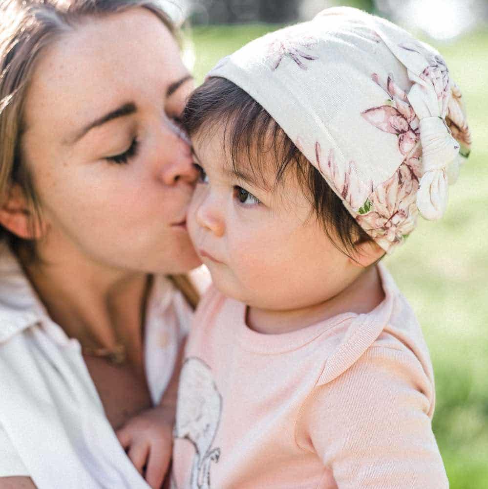 Sheep-print knotted beanie on toddler, light gray fabric with bow detail