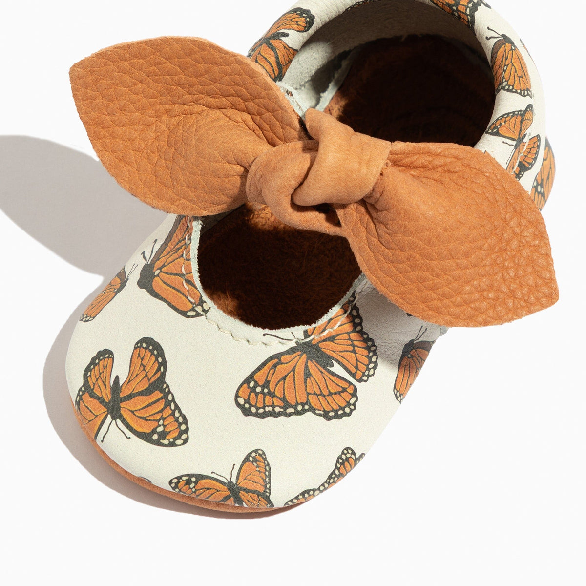 Knotted bow baby shoes, white fabric with orange monarch butterfly print and tan trim