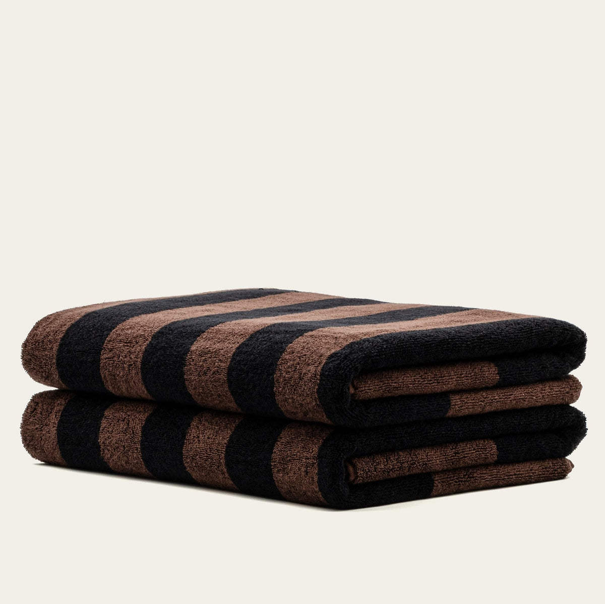 Folded bath towel with tobacco brown and black plaid blocks, rolled on end