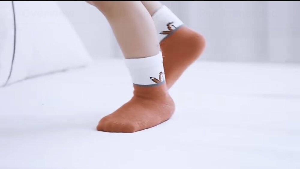 Toddler wearing orange fox socks with fox logo on cuff