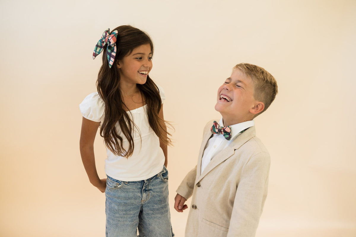 Plaid bow tie on boy's light shirt, green and brown check with navy accents