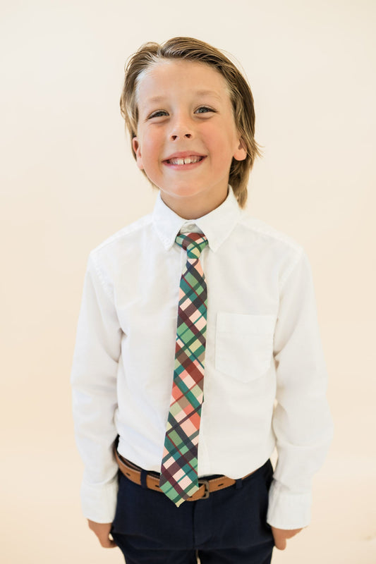Boys plaid tie worn with white dress shirt and navy trousers