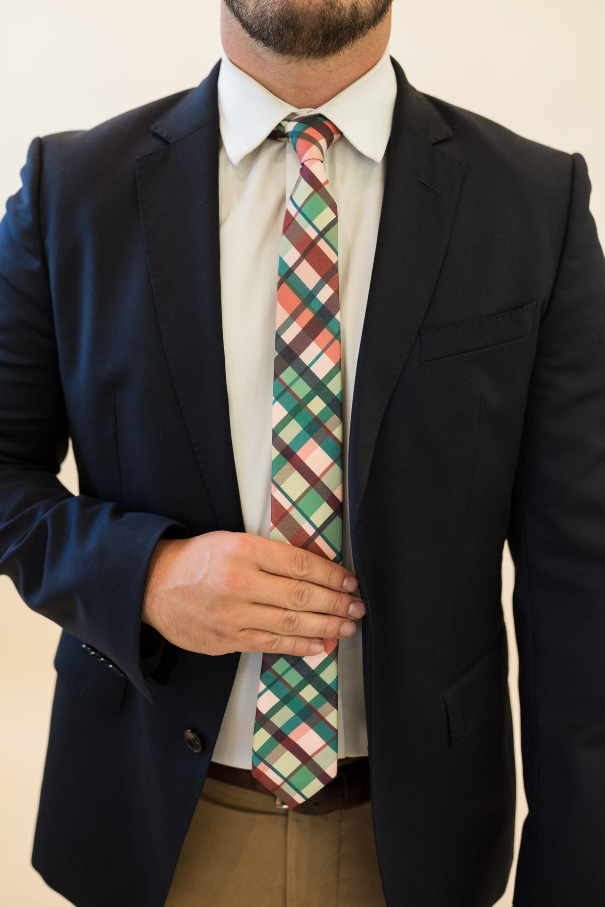 Men's plaid tie worn with a white dress shirt and dark suit jacket