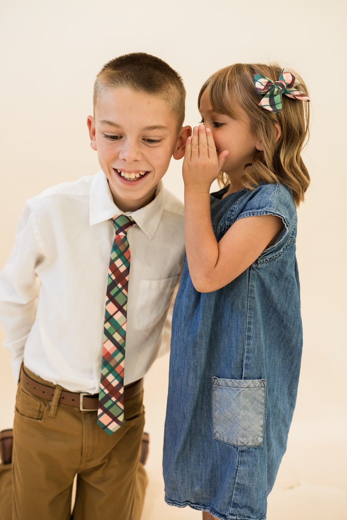 Youth plaid necktie on a child in a white shirt with teal, green, tan, and rust pattern