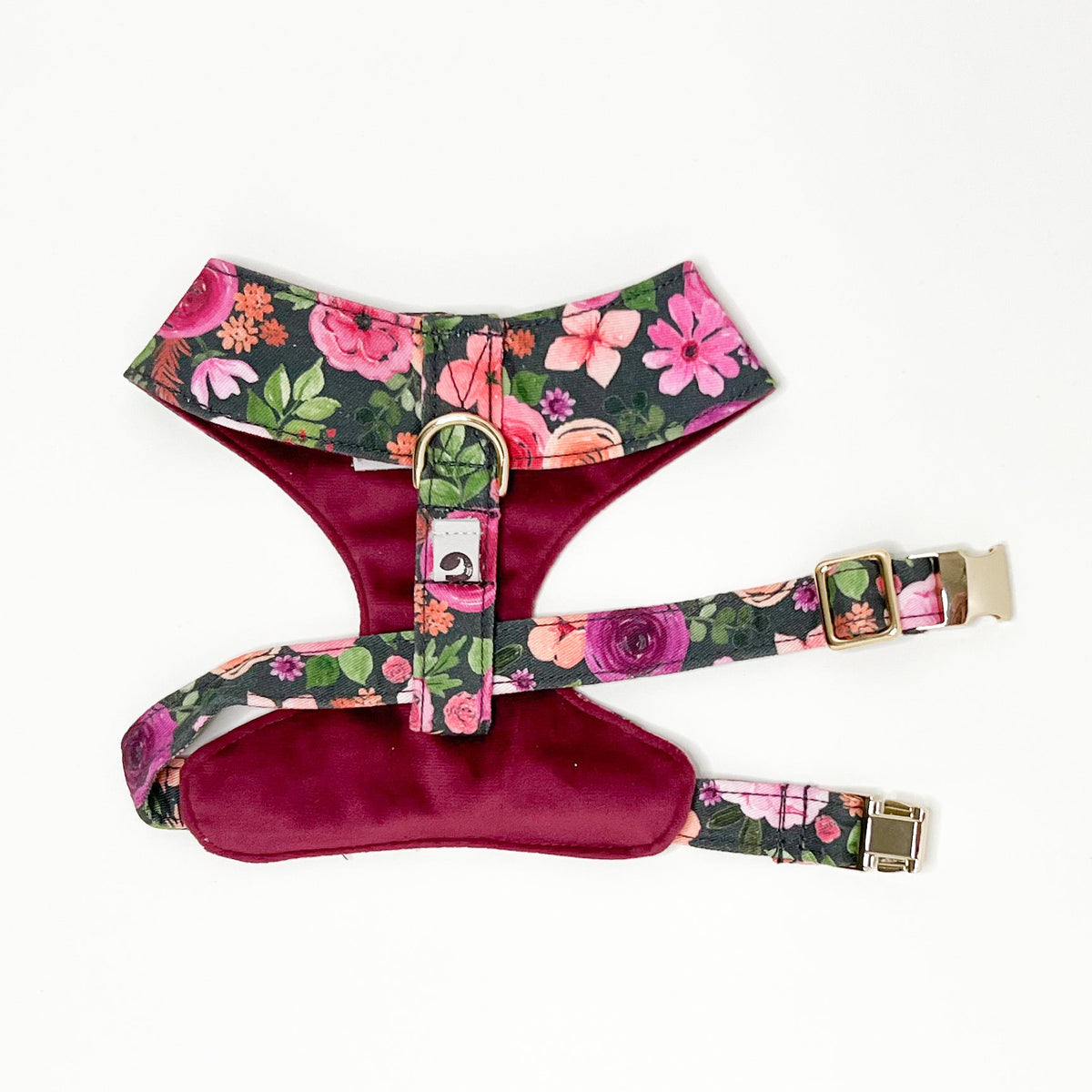 Reversible floral dog harness with maroon chest panel and gold buckle closure straps