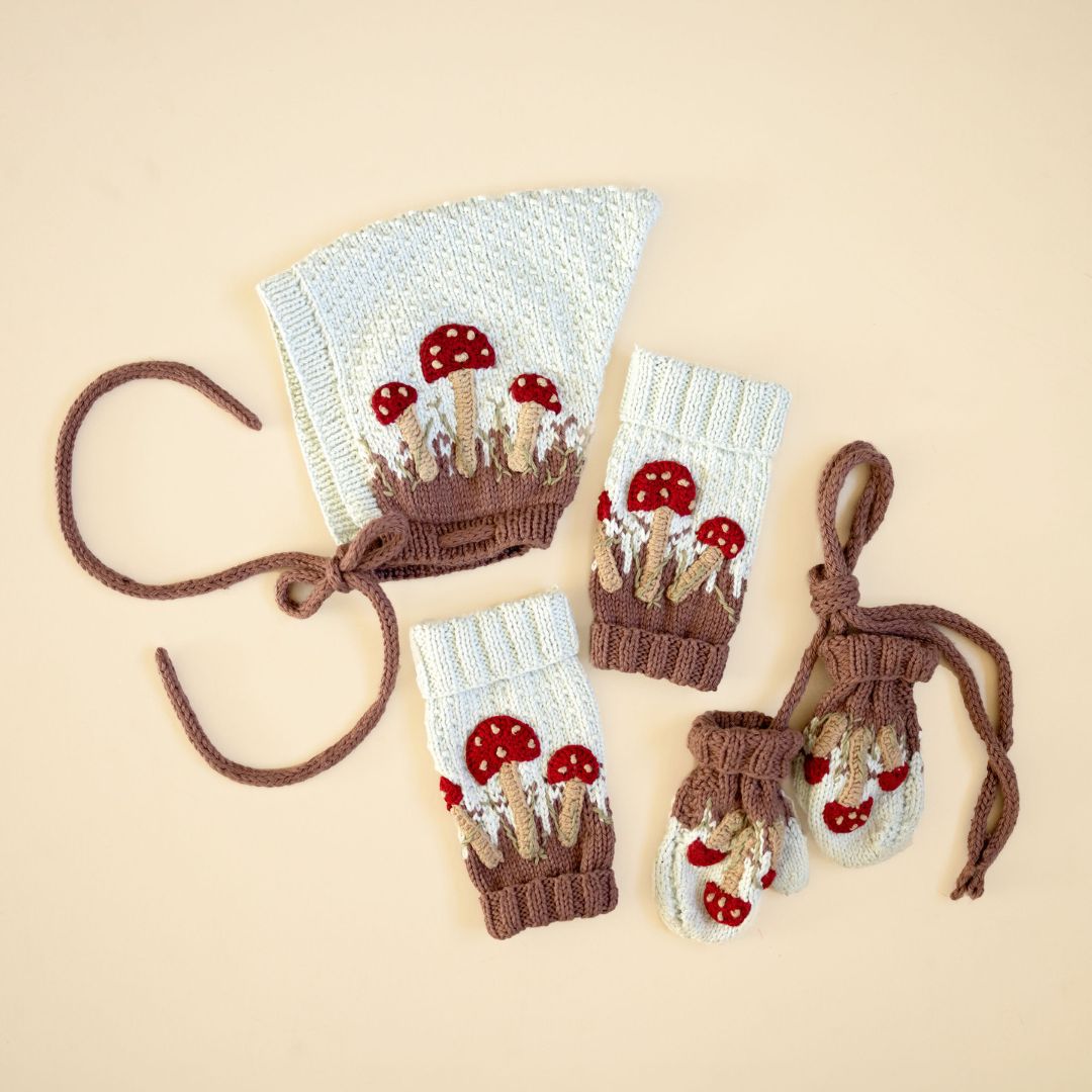 Knit mushroom accessory set: light cream, red-capped mushroom motifs, tied cuffs