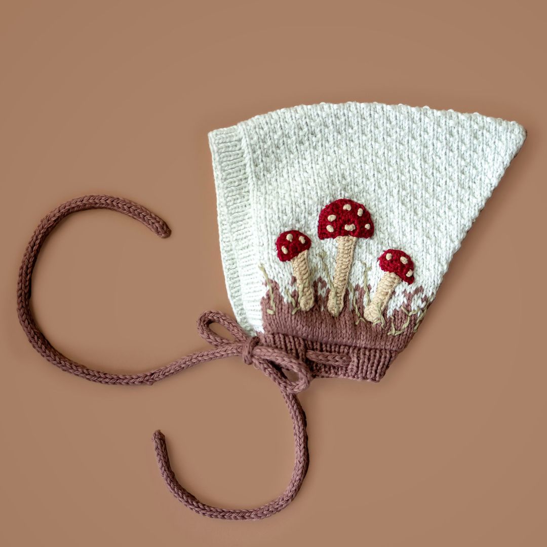 Light green knit pixie hat with red mushroom embroidery and mocha cuff